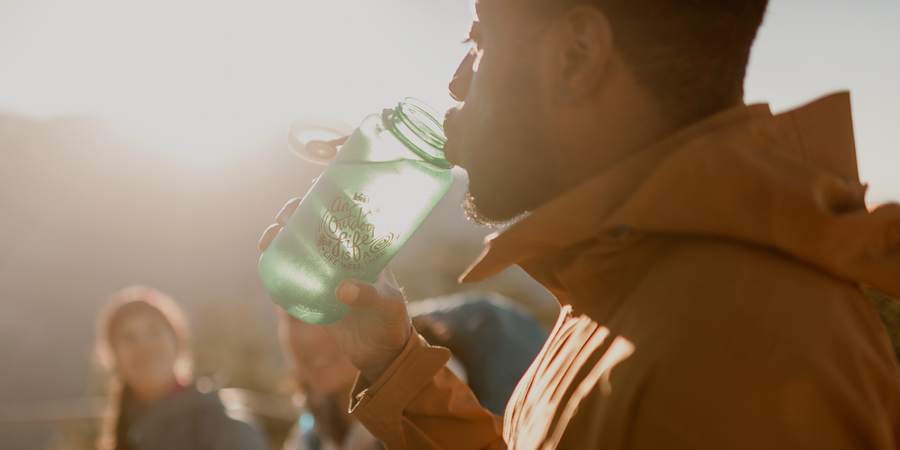 a hiker drinking from a water bottle