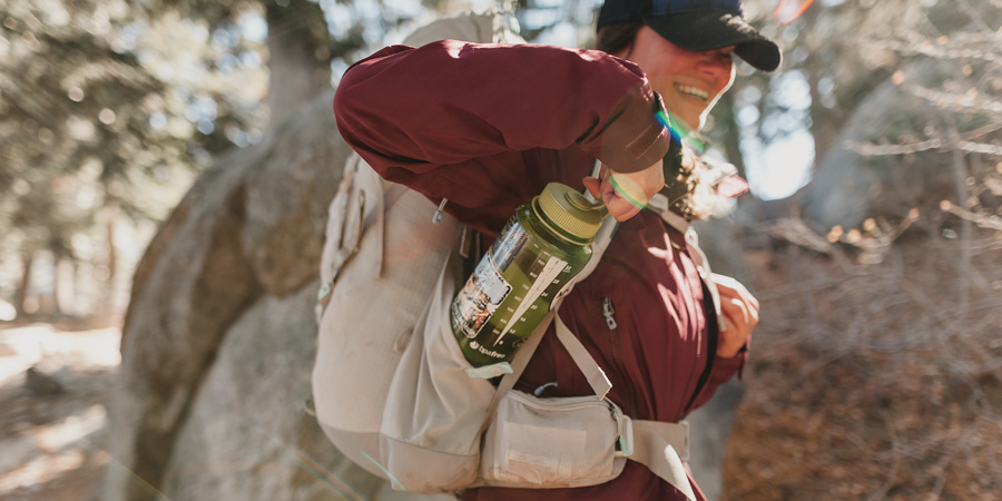 a hiker reaching for an easily accessible water bottle