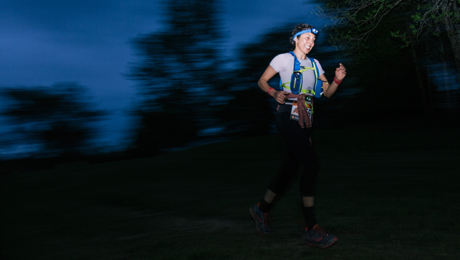 a trail runner running at night by headlamp