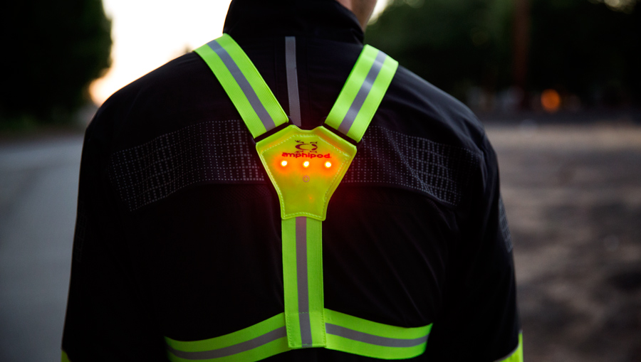 a runner wearing a high-visibility vest as they prepare for a night run