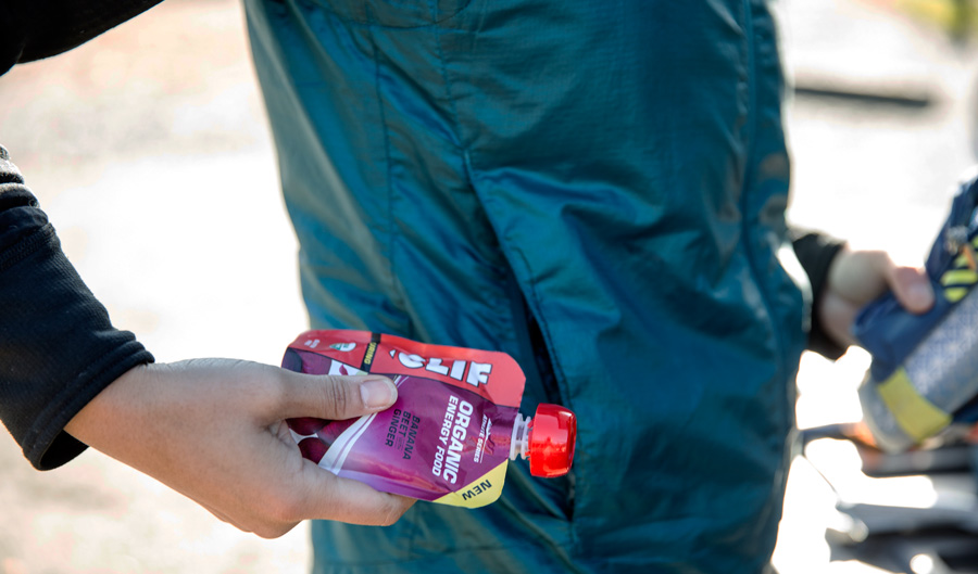 a trail runner placing some running gel in their pocket for the trail
