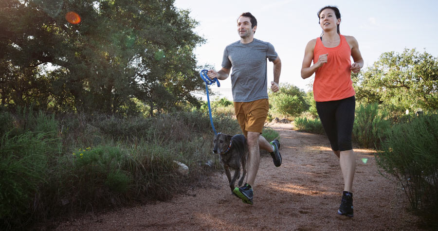 two trail runners on the trail with their dog