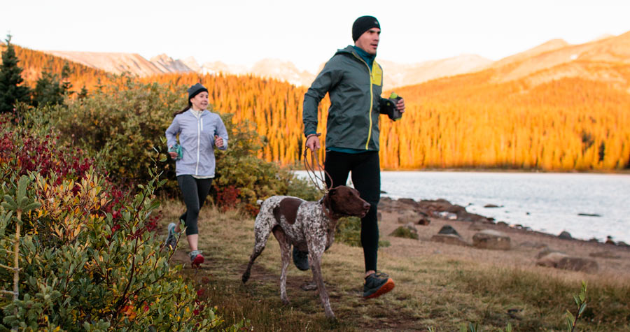 two trail runners on the trail with their dog