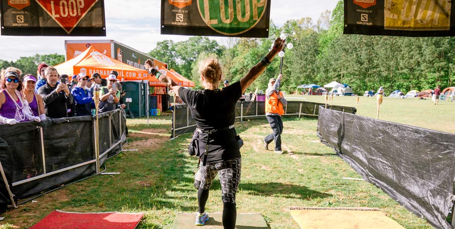 a ragnar trail running relay participant crossing the finish line with arms up in celebration