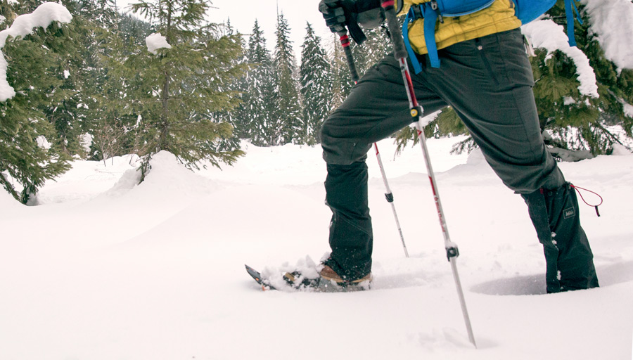 a snowshoer making their way through deep snow with gaiters on