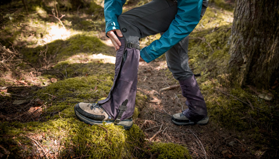 a hiker adjusting their gaiters to fit properly