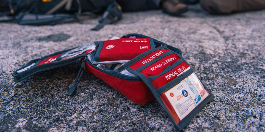 a hiking first aid kit open and on the ground