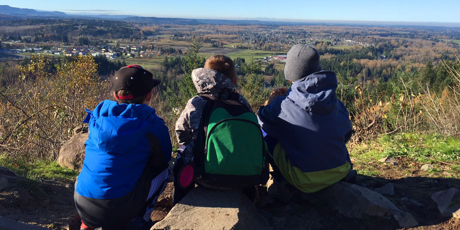 three young hikers looking out of a view point