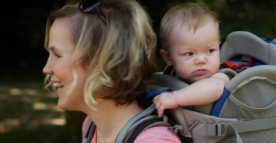 a young infant in a backpack child carrier