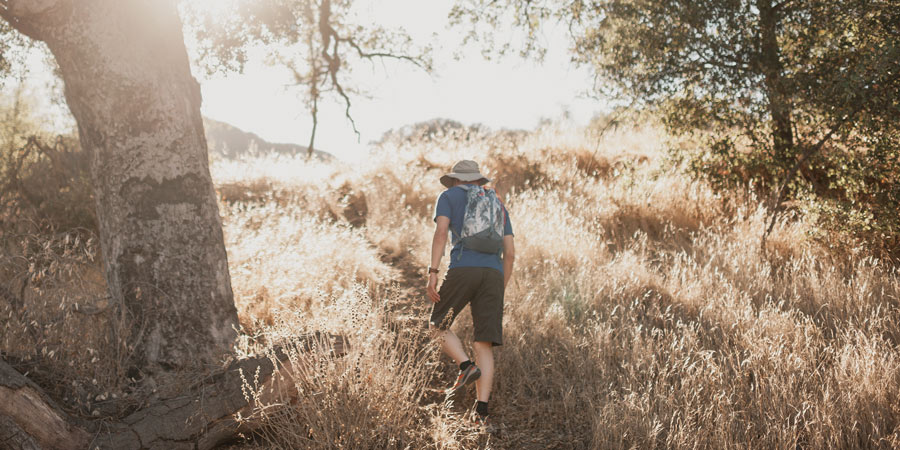 a hiker taking refuge in the shade on hot hiking day