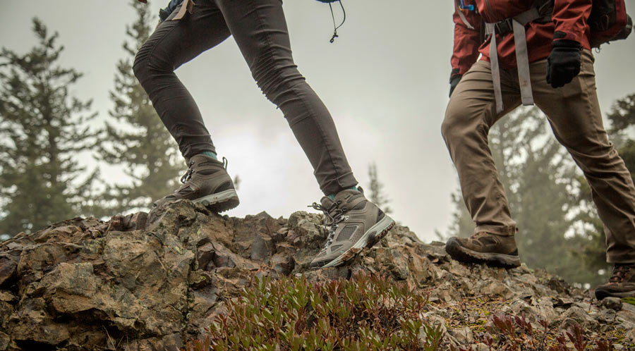 fitnessinf Expert Advice: How to Go Backpacking in the Rain - two backpackers watching their step on steep slippery terrain in the rain