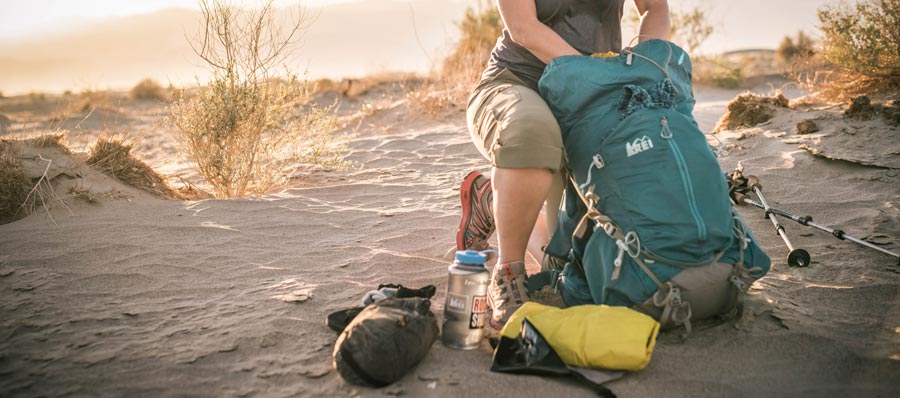 woman loading her backpack with gear