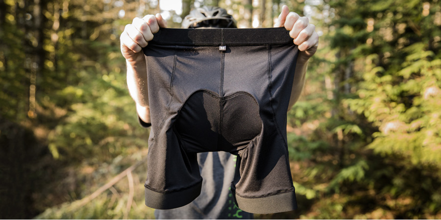 a biker holding up a pair of padded bike shorts