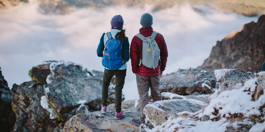 two hikers looking out over a view point on a cold day