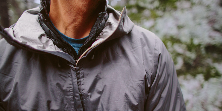 detail of a hiker wearing a base layer, insulating mid layer, and shell layer for a cold day on the trail