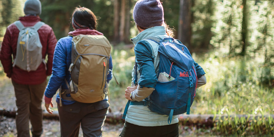three hikers on the trail with their daypacks on